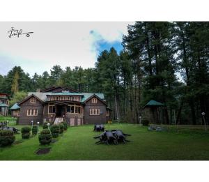 a large house with horses in front of it at Hotel Aksa Resort, Pahalgam in Pahalgām
