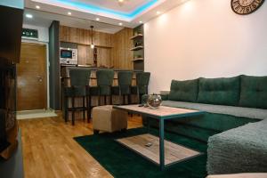 a living room with a green couch and a table at Apartman Knez 2 in Zlatibor