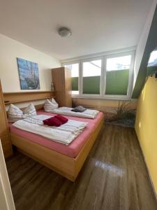 ein Schlafzimmer mit zwei Betten und zwei Fenstern in der Unterkunft Ferienwohnungen Norderney Haus Julianne Wohnung Steuerbord Familie Poppinga in Norderney