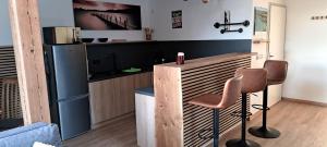 - une cuisine avec un comptoir et 2 chaises dans une pièce dans l'établissement Ferienwohnung Ruhepol, à Altefähr