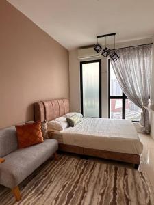 una camera con letto, divano e finestra di Highpark Suites ByTheNook a Petaling Jaya
