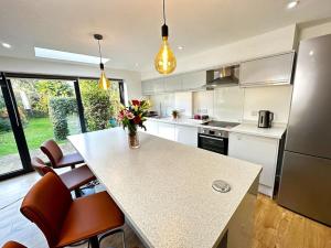 a kitchen with a table with a vase of flowers on it at Hutchcomb Villa, 4 Bed Luxury House,Oxford+Parking in Oxford