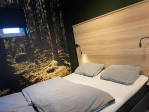 a bedroom with two beds and a tv on the wall at Apartment Lilletveitvegen in Bergen