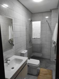 La salle de bains blanche est pourvue de toilettes et d'un lavabo. dans l'établissement La Joie Al Jadid, à Nador