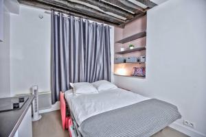 a small bedroom with a bed and a window at 1 bedroom apt only 15 min walk to The Louvre in Paris
