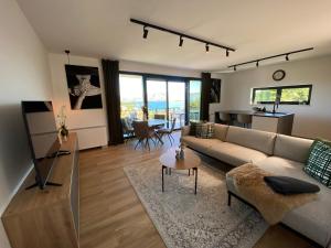 salon z kanapą i stołem w obiekcie Apartment Adria mit traumhaften Blick auf das Meer w mieście Lumbarda