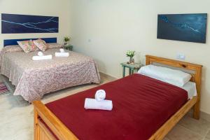 1 dormitorio con 2 camas y toallas blancas. en Amaragua en Fiambala