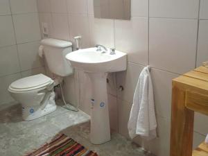 uma casa de banho com um lavatório branco e um WC. em Amaragua em Fiambalá