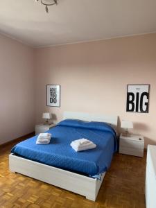 ein Schlafzimmer mit einem großen Bett mit blauer Bettwäsche und 2 Tischen in der Unterkunft Casa Asia in Seriate