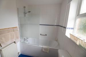 a white bathroom with a tub and a sink at Foss Flat in York