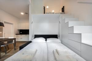 Cama blanca en habitación con escalera en Apartma Juniper, en Kranjska Gora