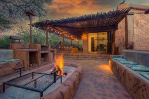 a fire pit in front of a house at Kaya KaBush in Marloth Park