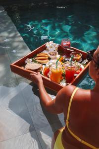 Una donna che tiene un vassoio di cibo in piscina di Alanta Pool Villa a Ko Lanta