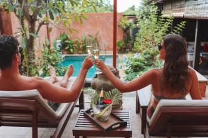 two people sitting at a table with glasses of wine at Alanta Private Pool Villa in Ko Lanta