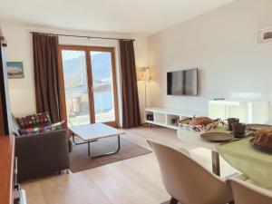 sala de estar con mesa, sillas y TV en Appartements Skida, en Reith bei Kitzbühel