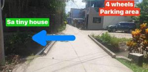 una calle con una flecha azul apuntando a una zona de estacionamiento en Daet Transient Tiny House staycation 2-6px, en Daet
