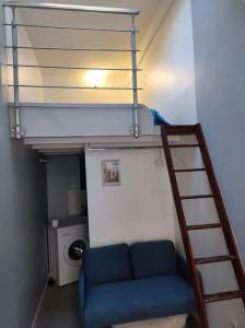 een woonkamer met een blauwe bank en een ladder bij Garibaldi mini-maison jardin in Saint-Ouen
