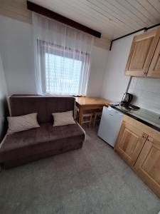 ein kleines Wohnzimmer mit einem Sofa und einem Tisch in der Unterkunft Apartmani "DA HOX" Vlašić 2 in Vlasic