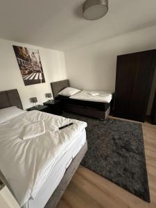 a bedroom with two twin beds and a rug at bee Apartment 10 Betten für Gruppen & Monteure PS5 in Fellingshausen
