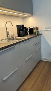 a kitchen with white cabinets and a sink at bee Apartment 10 Betten für Gruppen & Monteure PS5 in Fellingshausen