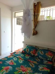 a bedroom with a bed and a statue on the wall at Kay Anaisa in Le Morne Rouge