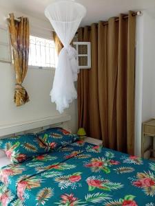 a wedding dress hanging from a window in a bedroom at Kay Anaisa in Le Morne Rouge