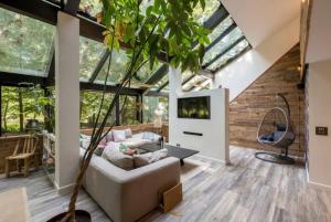 ein Wohnzimmer mit einem weißen Sofa und einem Baum in der Unterkunft 5 Star Luxury Woodland Retreat Sleeps 12 Hot tub Sauna in Clapton in Gordano + 70 Fotos