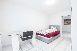 1 dormitorio con escritorio, 1 cama y 1 silla en 3.5 Room Apartment en Würenlos