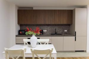 a kitchen with a table and chairs and a vase with flowers at Wunderschöne, neue gebaute 2023 Apartments Aurelija in Reutlingen