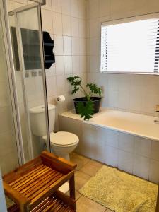 baño con aseo y bañera con planta en Aporto Villa, en Reebok