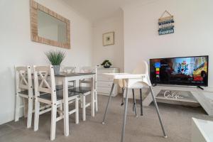 une salle à manger avec une table et une télévision dans l'établissement Light and airy 1 bedroom flat 700m from the Beach, à Bournemouth