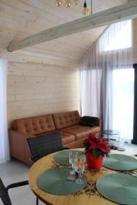 uma sala de estar com um sofá e uma mesa em Smiltsērkšķu namiņš 