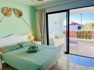 1 dormitorio con 1 cama grande y balcón en Fantastic sea and golf course view house with 3 bedrooms en San Miguel de Abona