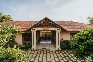 una casa con un pabellón con una mesa en ella en Aadisaktthi Leisure Resort, Kovalam en Thiruvananthapuram