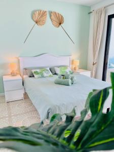 Un dormitorio con una cama blanca y una planta en Fantastic sea and golf course view house with 3 bedrooms en San Miguel de Abona