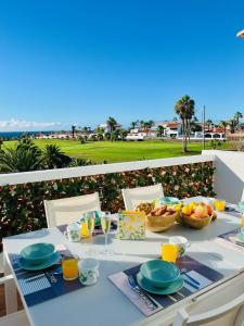 Fantastic sea and golf course view house with 3 bedrooms في سان ميغيل ذي أبونا: طاولة مع الطعام والمشروبات على شرفة مع المحيط