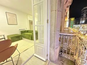 uma porta aberta para um quarto com um sofá verde em Elegante hogar en el centro em Vigo