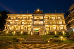 a large building with stairs in front of it at night at Aadisaktthi Leisure Resort, Kovalam in Trivandrum