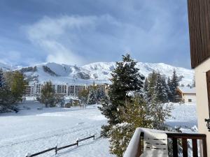 a snow covered yard with a building and a mountain at Grand T3- pied des pistes-63 m2-8 personnes in La Toussuire