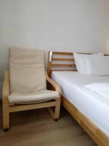 a bedroom with a bed and a chair at Hotel Hanseatic-garni in Wuppertal