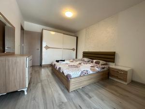 a bedroom with a bed and a wooden floor at 4-YOU Apartment in Ferizaj