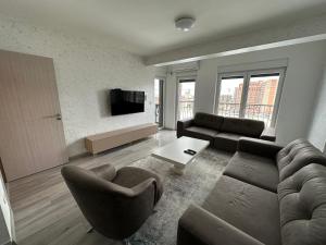 a living room with a couch and a table at 4-YOU Apartment in Ferizaj