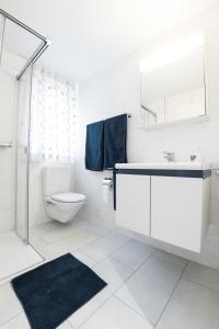 La salle de bains blanche est pourvue d'un lavabo et de toilettes. dans l'établissement 3.5 Room Apartment, à Würenlos