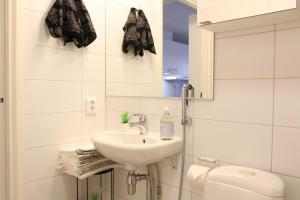 Un baño blanco con lavabo e inodoro. en Suite Apartment KIELO in Center near all the main spots, WiFi, en Rovaniemi