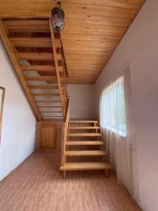 Una escalera en una habitación con techo de madera en KRI Holiday House, en Alūksne