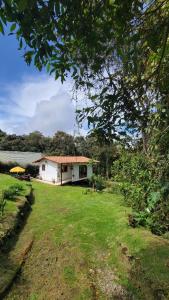 uma pequena casa branca com um jardim de relva em alto palmas 2.0 em Medellín