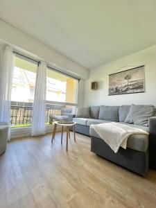 sala de estar con sofá y mesa en L'échappée Cabourgeaise, en Cabourg