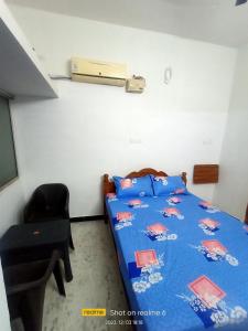 1 dormitorio pequeño con 1 cama y 1 silla en LA villa Rani, en Madurai