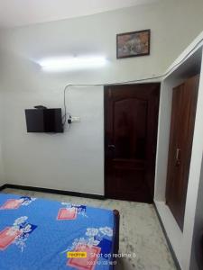 Habitación con cama, puerta y puerta en LA villa Rani, en Madurai