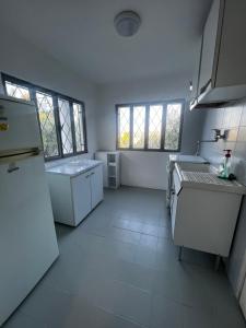 eine weiße Küche mit einer Spüle und einem Kühlschrank in der Unterkunft Casa indipendente vista mare in Imperia